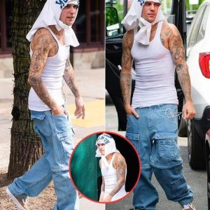 Justin Bieber wraps shirt around his HEAD as he showcases toned physique in clinging tank top in NYC